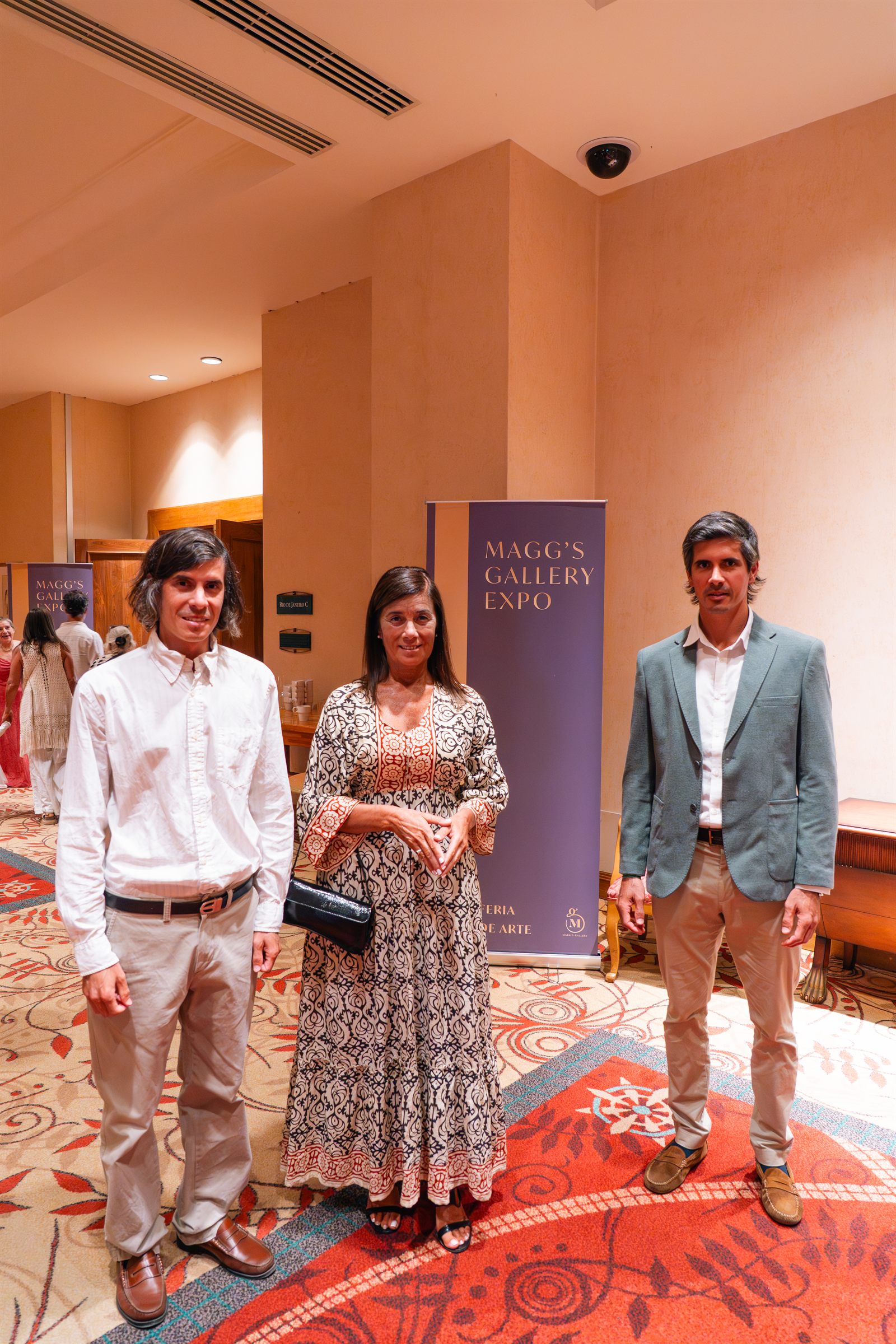Magg's Gallery Expo, equipo curatorial junto al rollup oficial